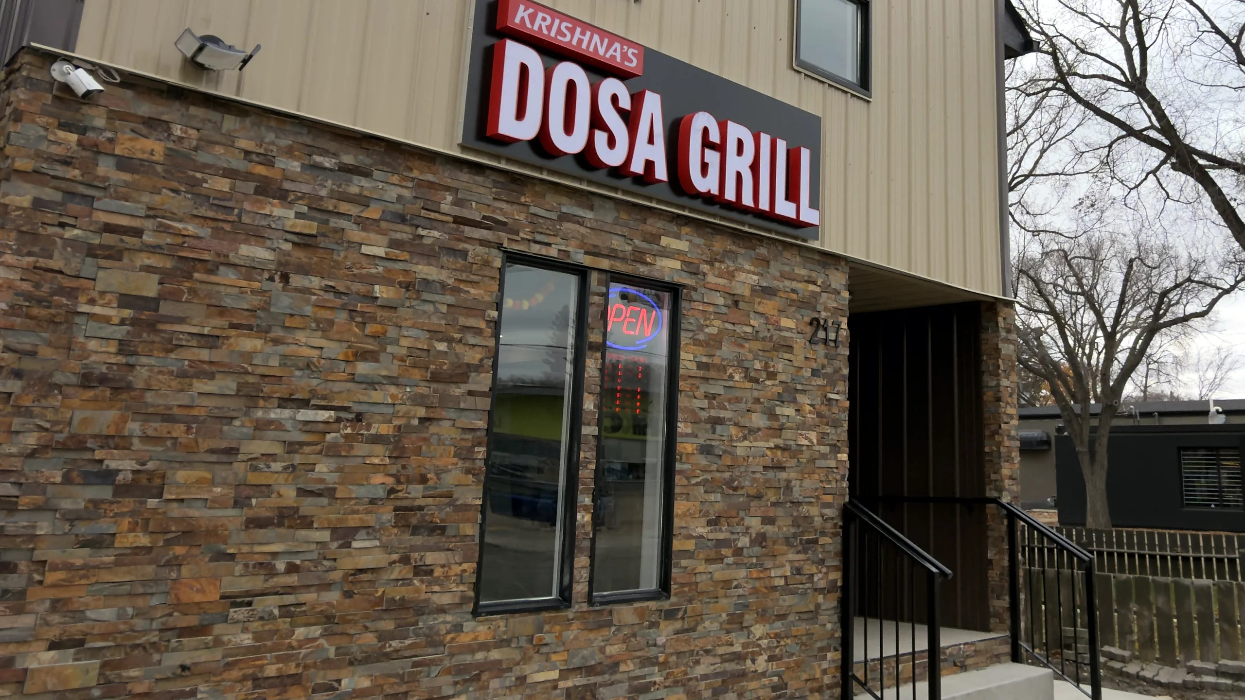 Krishna's Dosa Grill sign above the stone storefront at 217 33rd Street West, Saskatoon