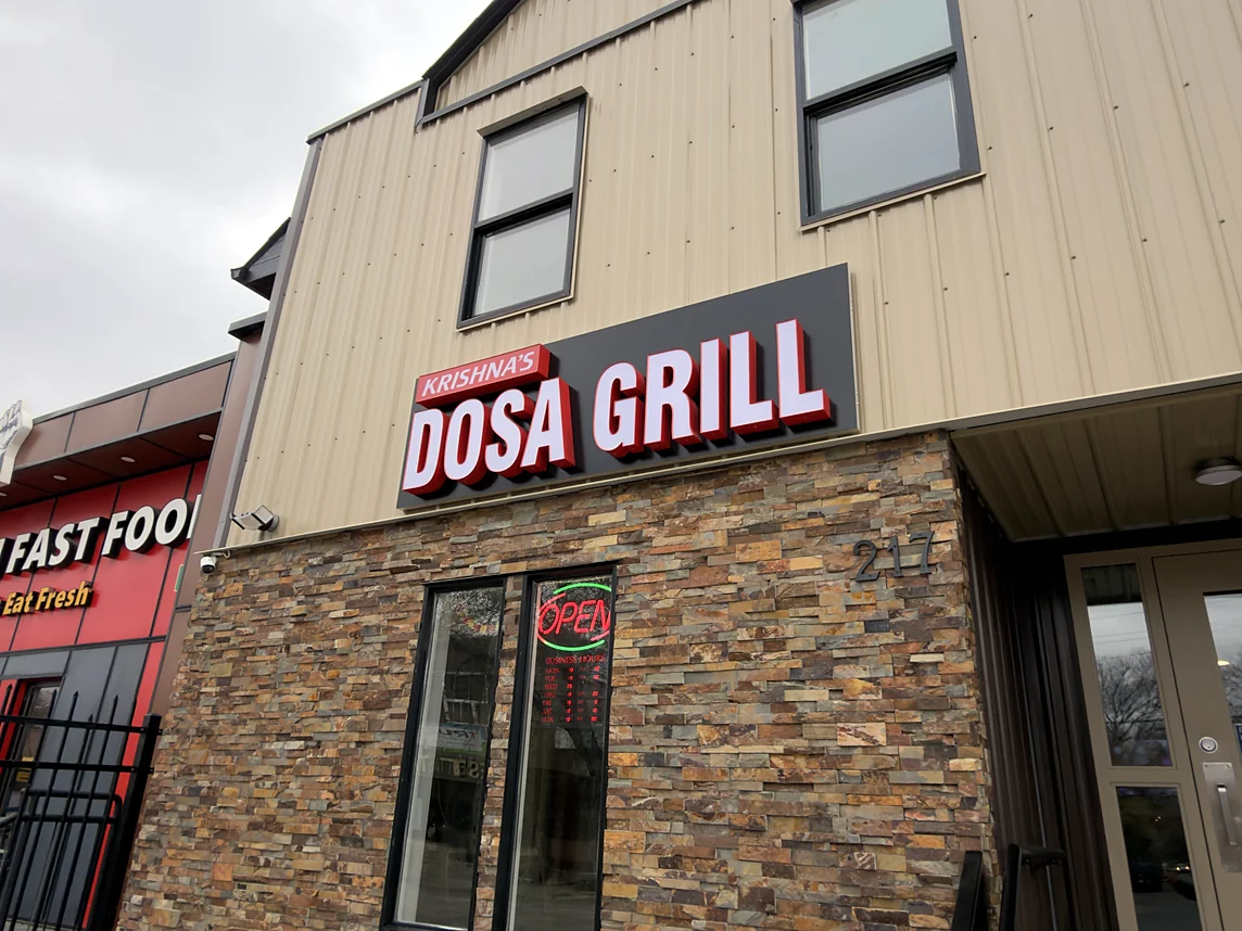 Krishna's Dosa Grill sign above the stone storefront at 217 33rd Street West, Saskatoon