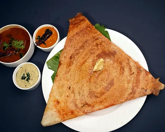 Mysore masala dosa folded into a triangle, with sambar and chutneys